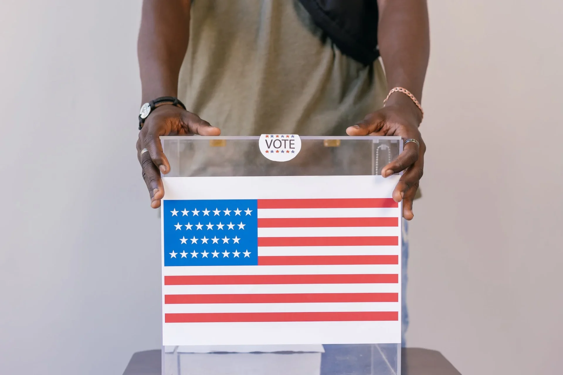 A person holding an american flag on top of a box.